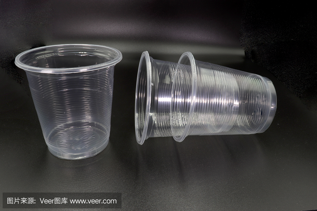 躺著和站著的塑料杯孤立在黑色的背景。高分辨率圖像庫。